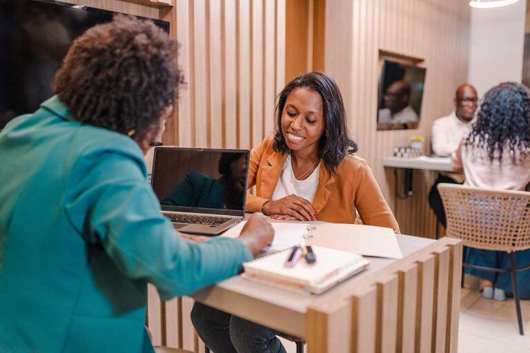 A person reviews recipient bank details and an international transfer receipt at a desk.